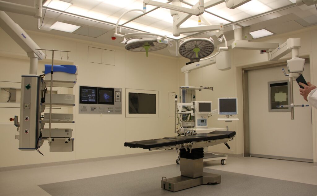 Modern operating room with an empty surgical table, medical monitors, overhead surgical lights, and various medical equipment—ready to support specialized care for organizations like Central Florida Animal Reserve.