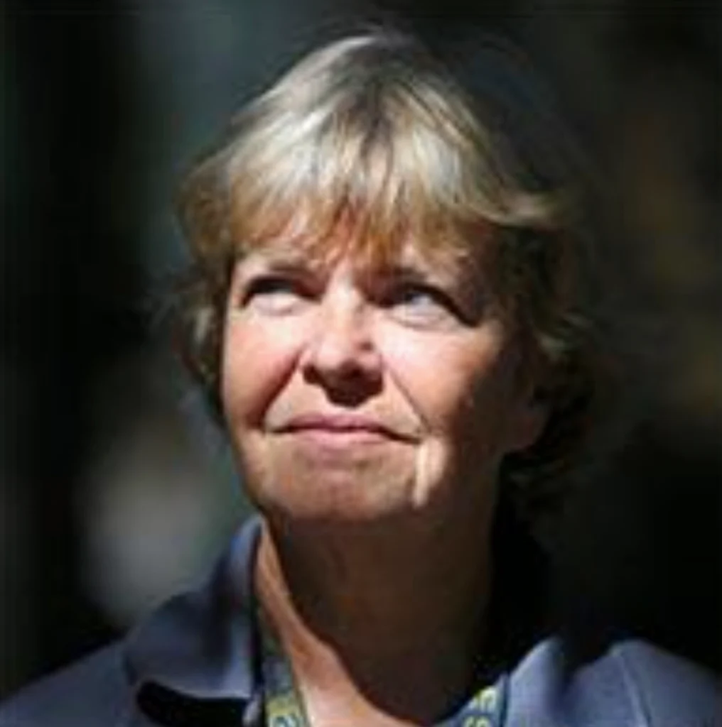 An older woman with short, light hair looks slightly upward. She is outdoors, lit by natural light, with a neutral expression—an image featured in the Central Florida Animal Reserve media kit.